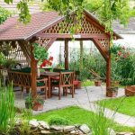 Beautiful wooden gazebo in the landscape of a garden plot