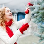 A woman decorates a New Year tree.