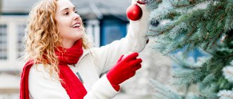 A woman decorates a New Year tree.